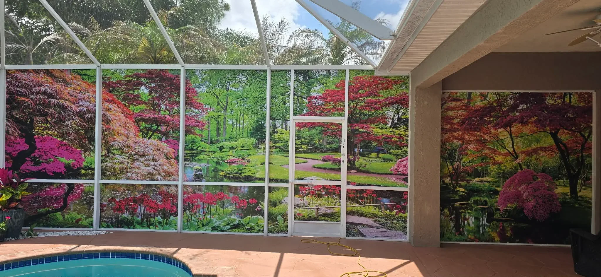 Large aluminum screen panels with clear screening framing garden landscape view, white frame, pool deck setting