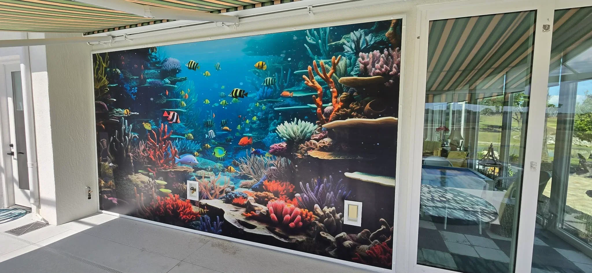Large coral reef mural with tropical fish and colorful corals installed on exterior wall
