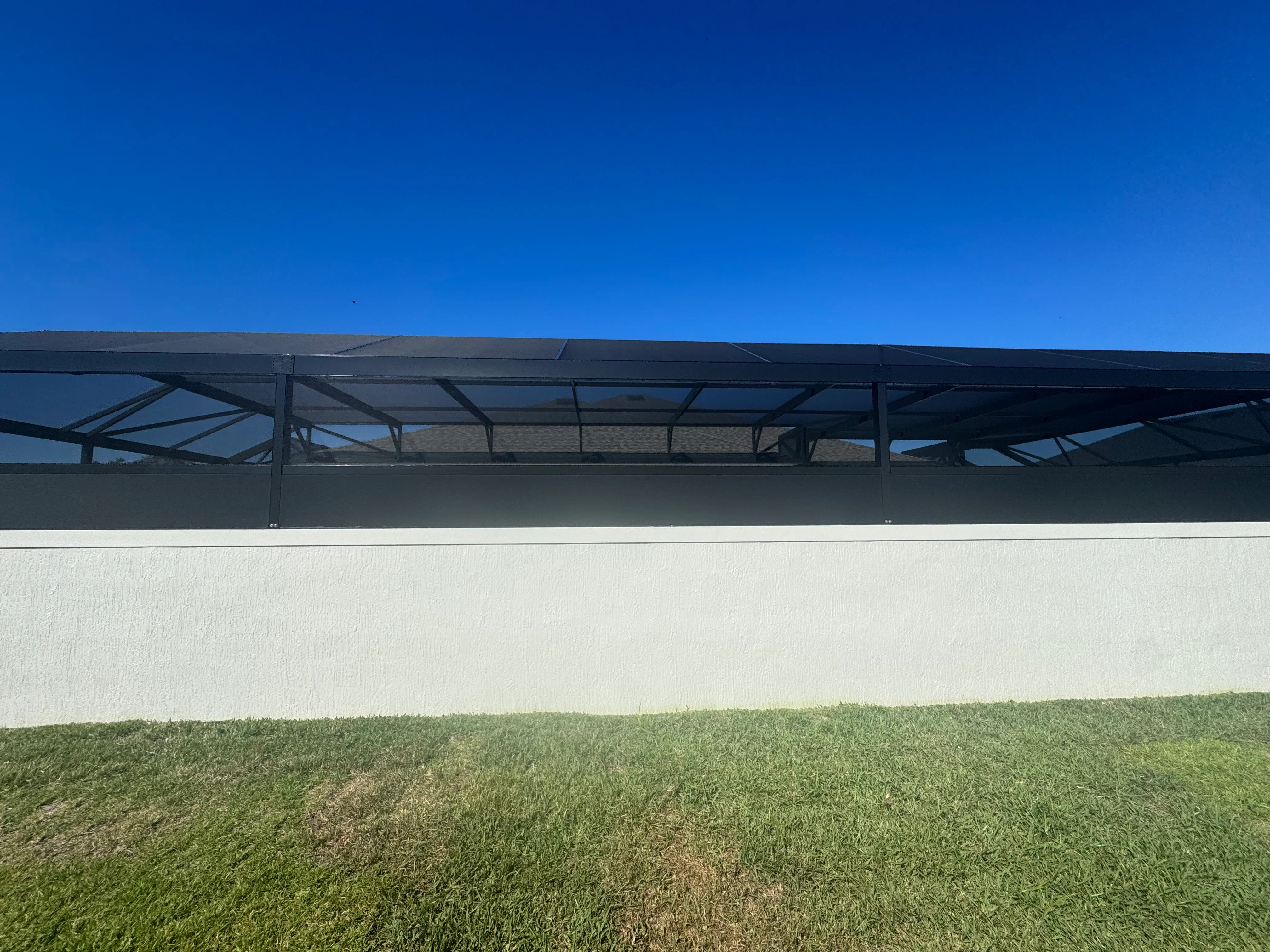 Retractable black aluminum screen system with mesh installed on residential patio