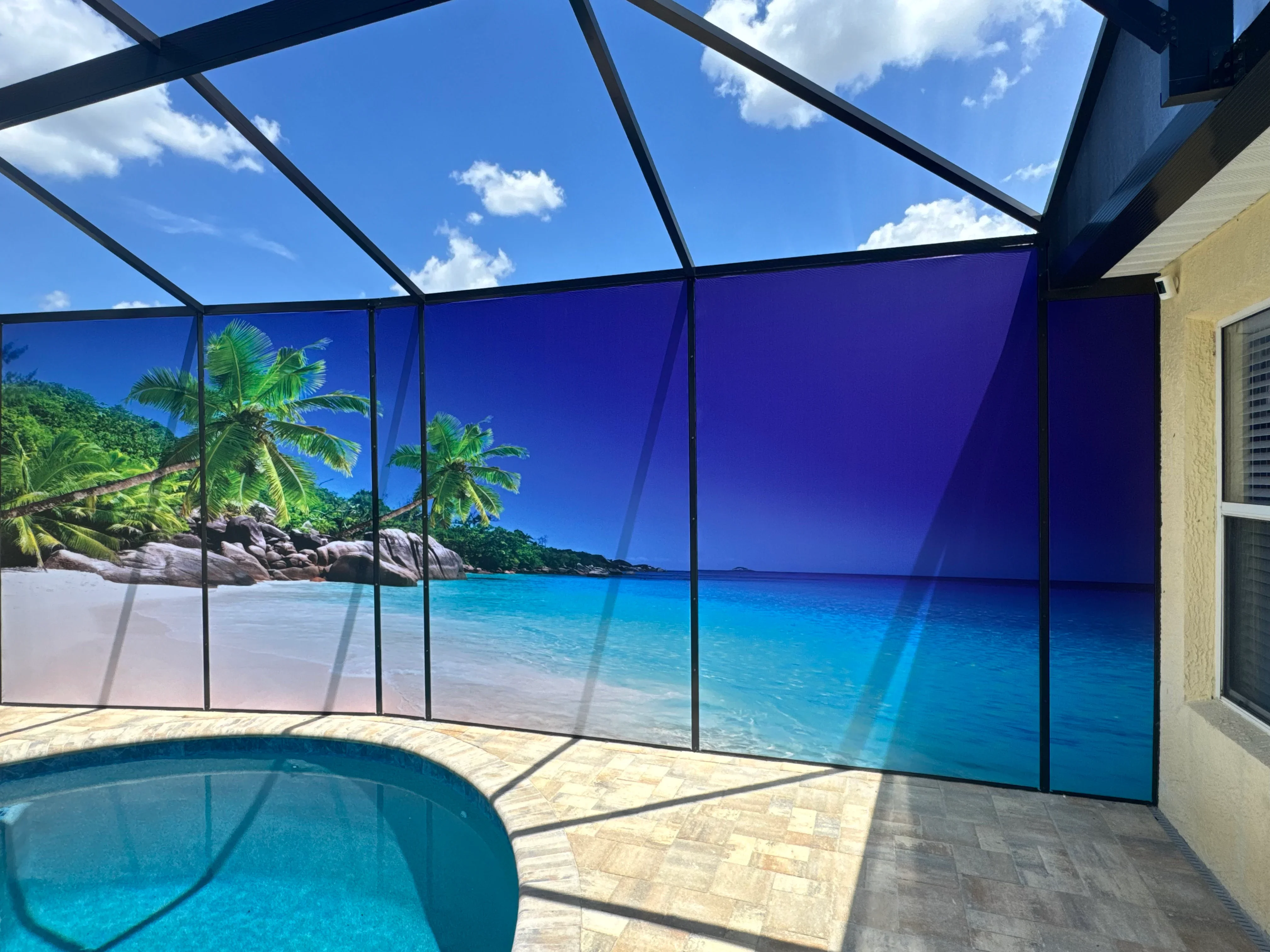 Pool enclosure with printed beach scene screens and polycarbonate roof panels