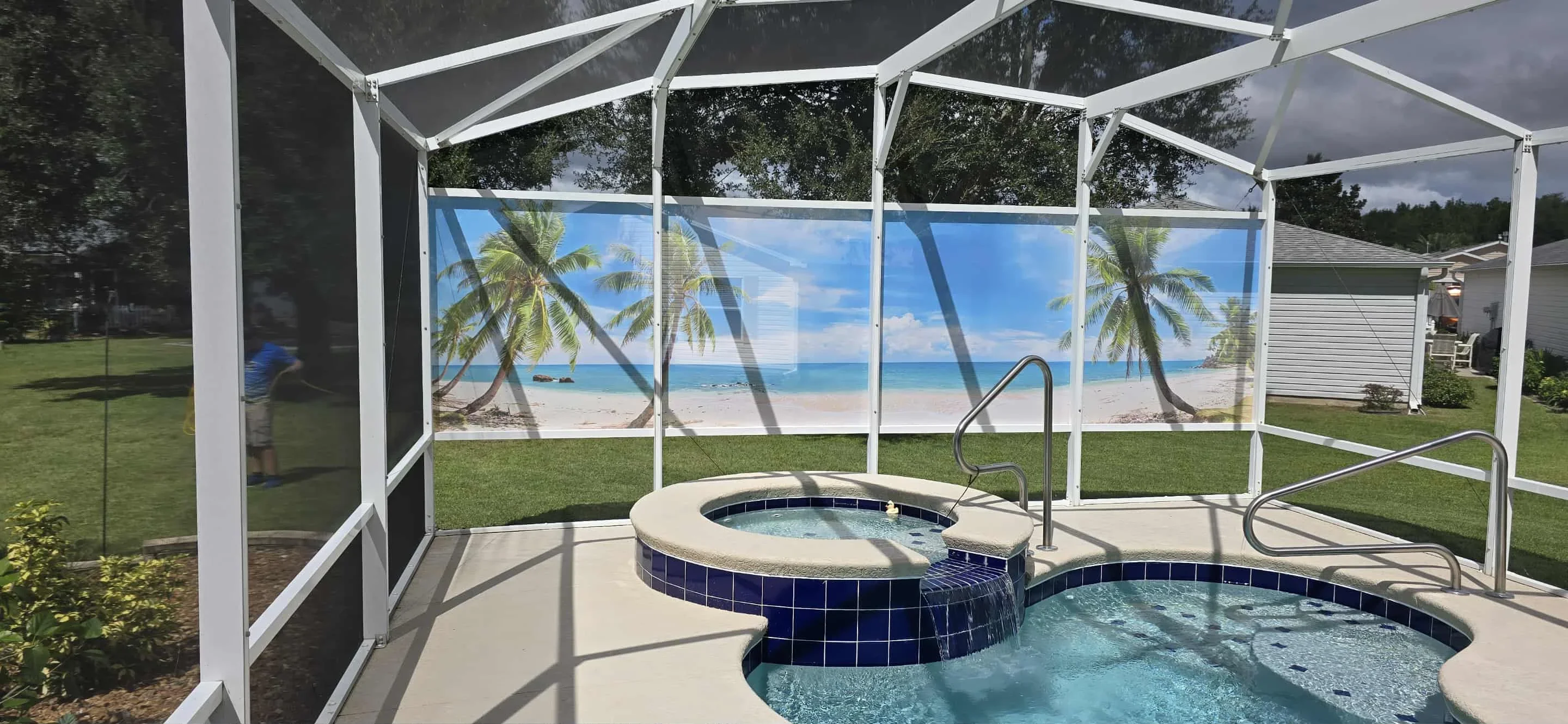 White aluminum screen enclosure with glass panels around pool and spa with blue tile trim