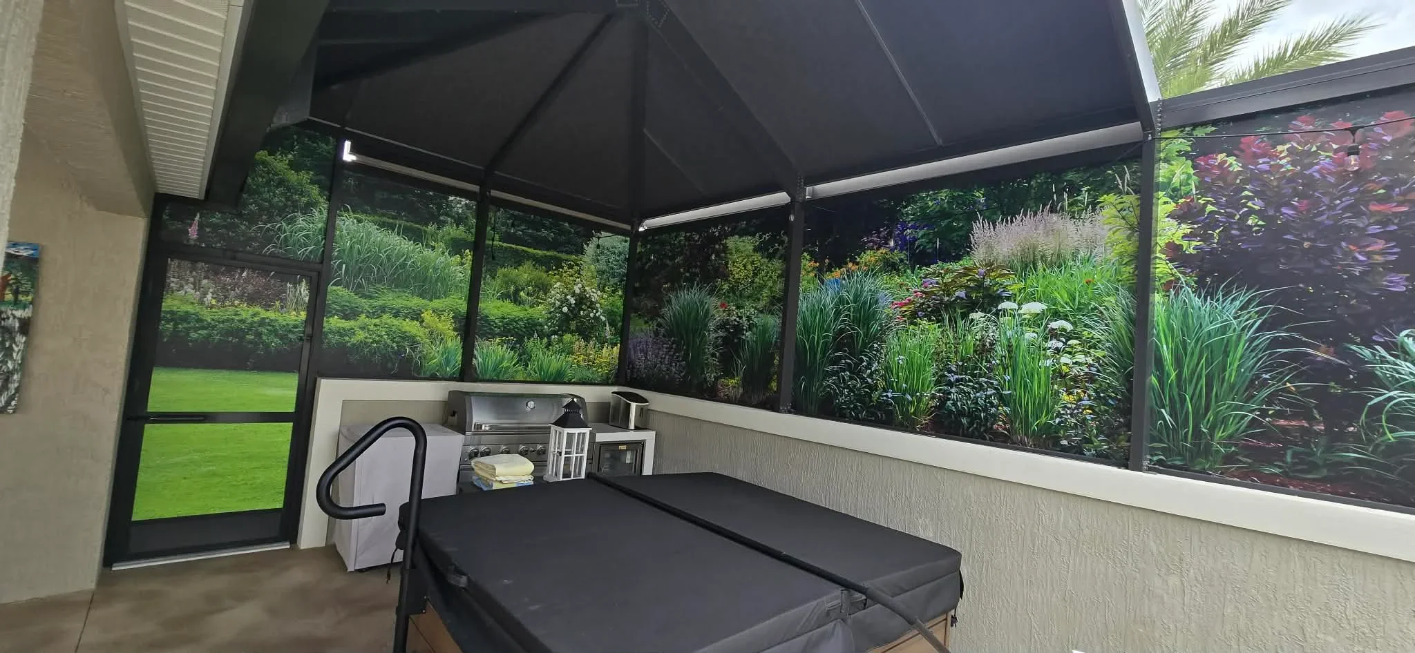 Retractable black shade screen over patio with glass panels, aluminum frame, and white wainscoting
