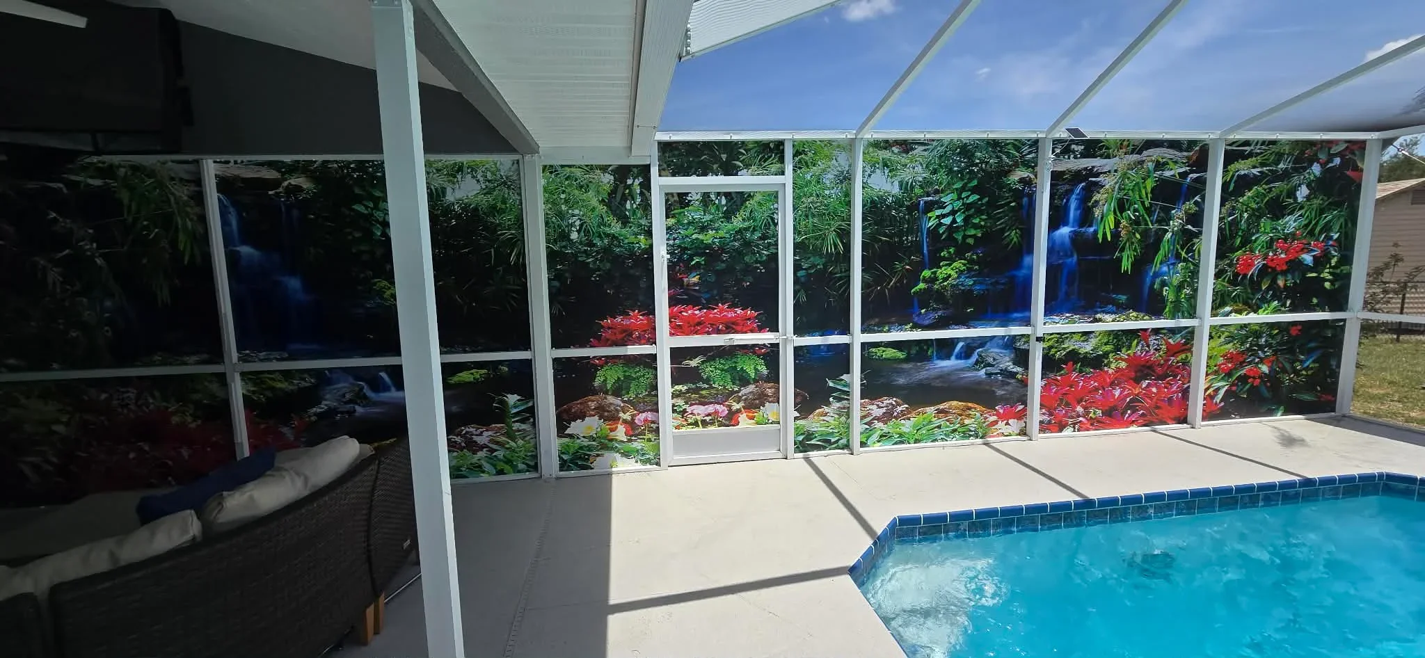 White aluminum screen enclosure with polycarbonate roof panels surrounding pool deck