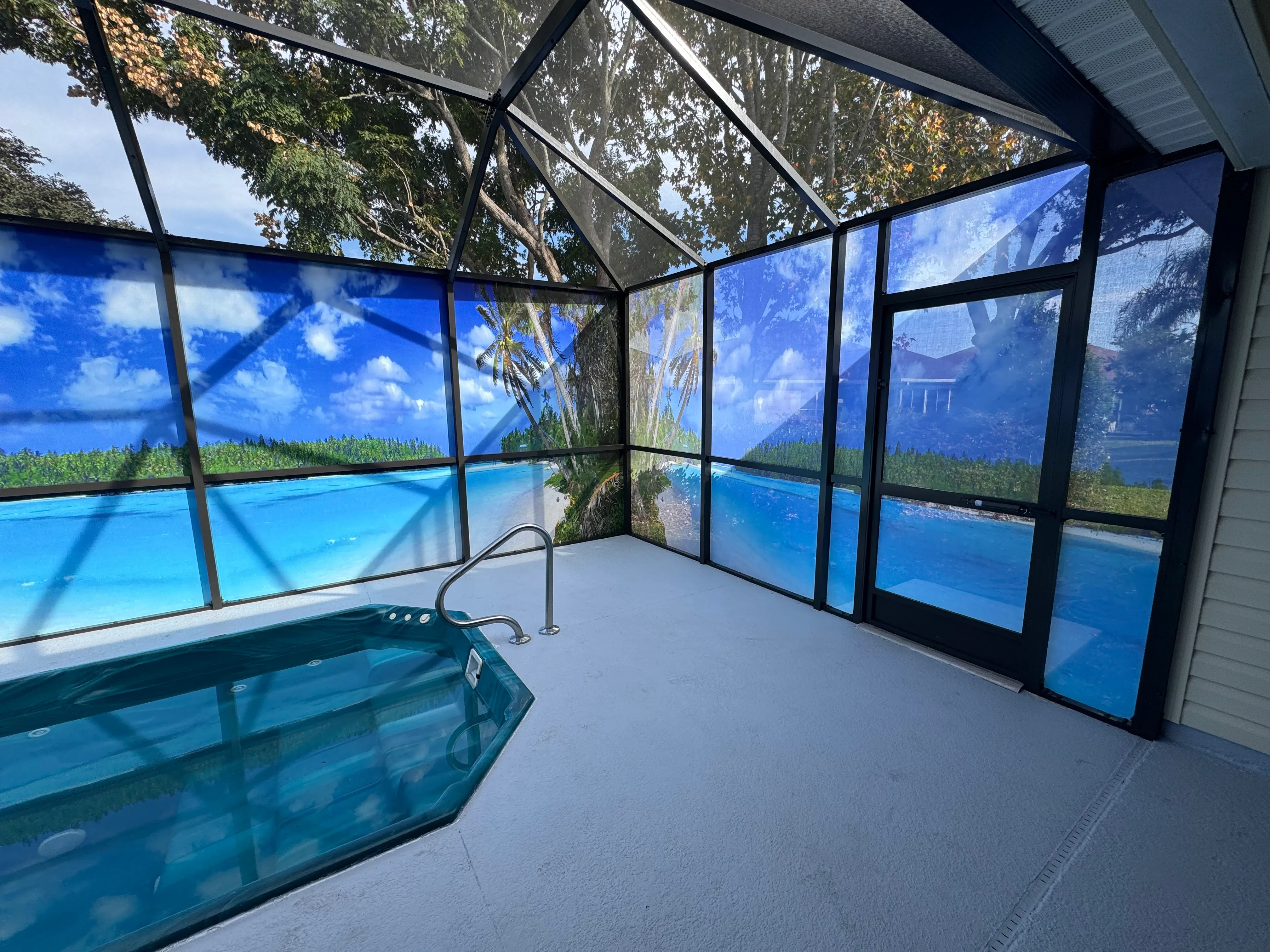 Black aluminum pool enclosure with screened panels, glass doors, and polycarbonate roof over spa