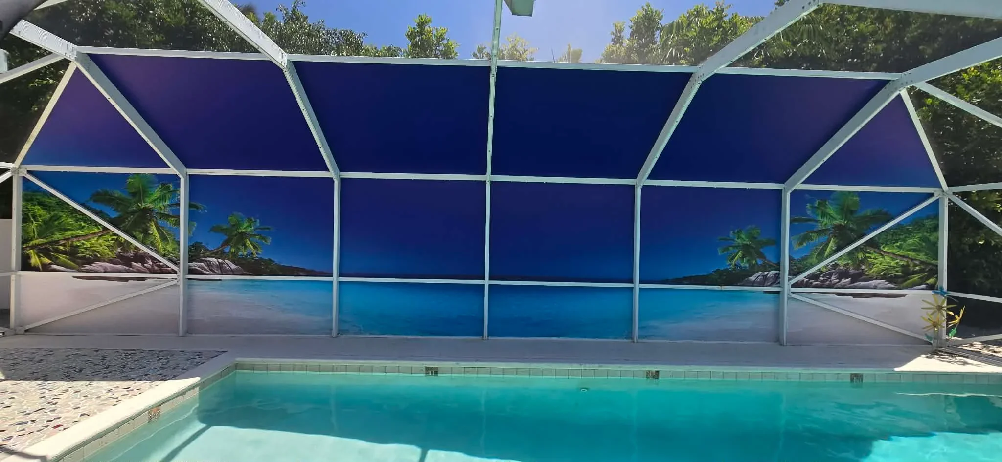 Pool enclosure with white aluminum frame, navy mesh panels, and tropical beach mural backdrop