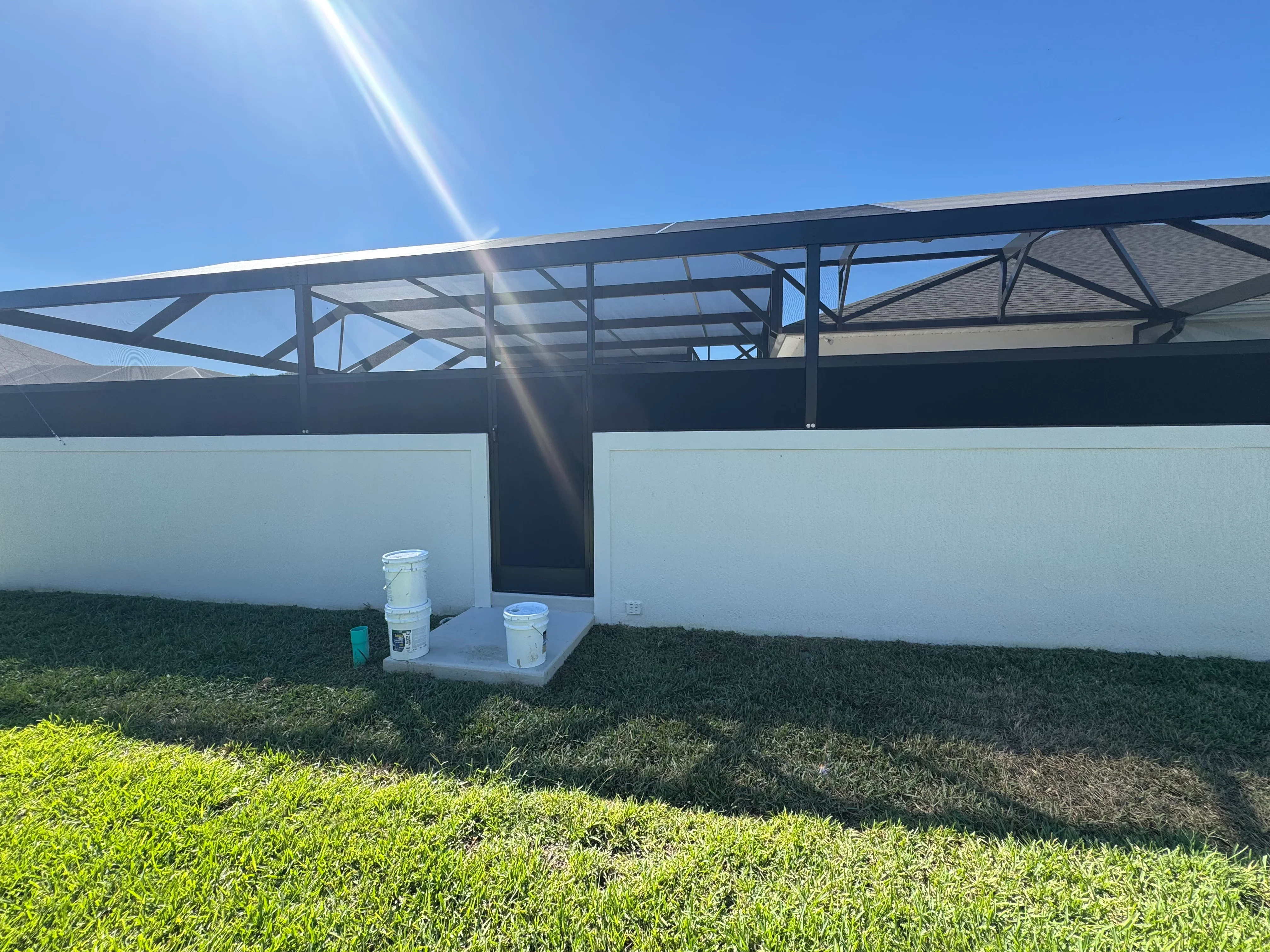 White vinyl screen panels with steel frame structure and open roof design on residential property